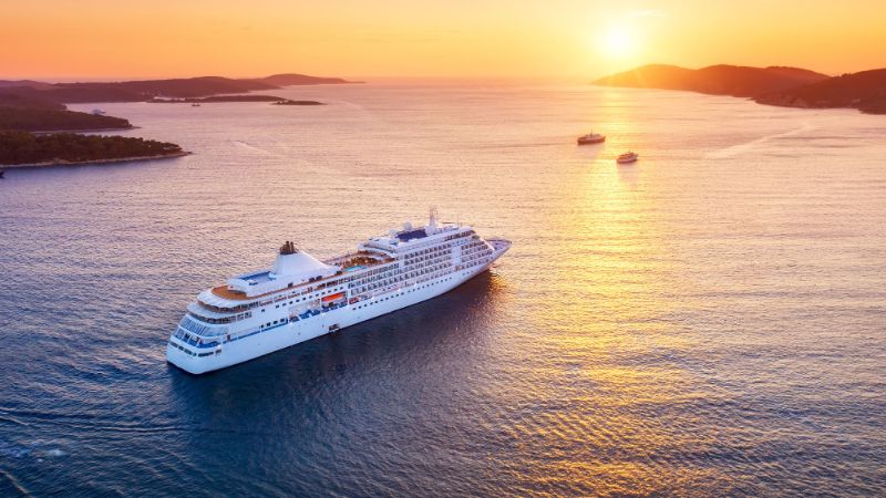 Aerial view cruise ship sailing across vast expanse water at sunset