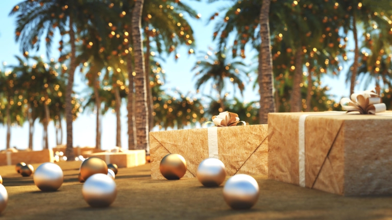 Festive gift boxes and holiday christmas ornaments under illuminated palm trees at a tropical beach destination