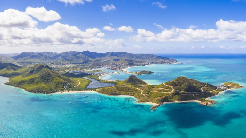 Aerial view of St John's, Antigua featuring turquoise bays, lush green hills and white-sand beaches
