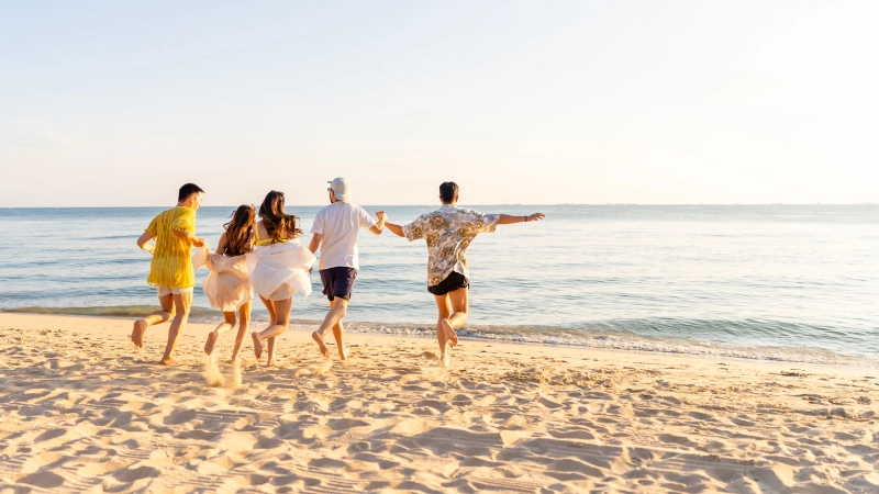 Group of friends running on the beach