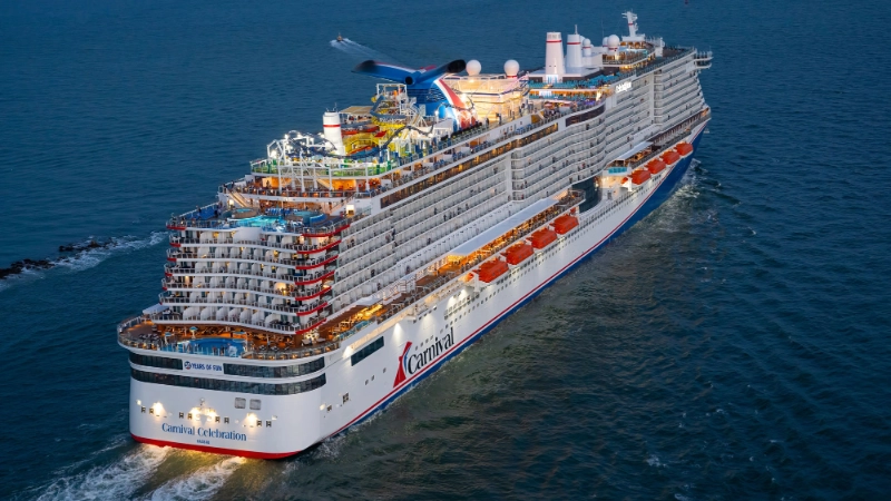 Carnival Celebration cruise ship sailing across the ocean at dusk