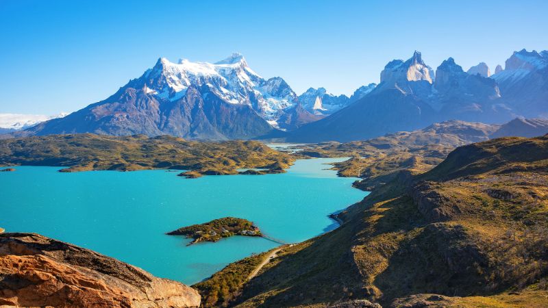 Panoramic view sparkling turquoise lake surrounded majestic snow capped mountains